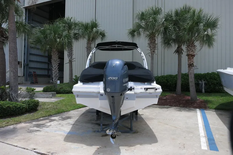 Slide: The Image of 2023 Chaparral 23 SSi OB boat with Yamaha outboard motor, parked near palm trees. - 6