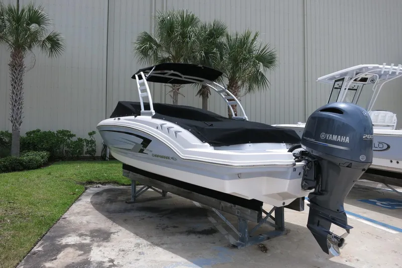 Slide: The Image of 2023 Chaparral 23 SSi OB boat with Yamaha engine, parked outdoors near palm trees. - 7