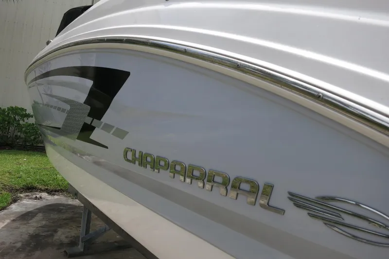 Slide: The Image of 2023 Chaparral 23 SSi OB boat side view with logo and sleek design. - 8