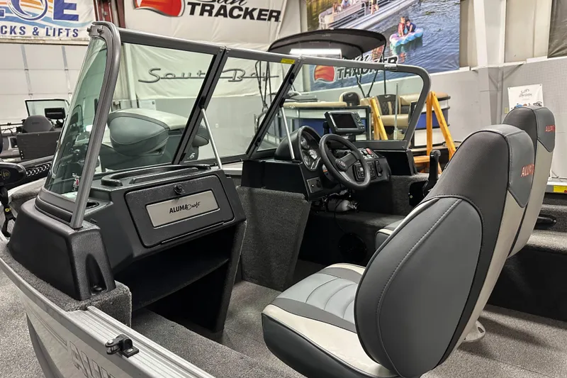 Slide: The Image of 2020 Alumacraft Classic 165 Sport boat interior with steering wheel and seating. - 10
