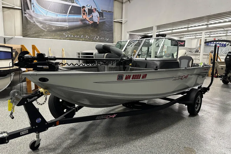 Slide: The Image of 2020 Alumacraft Classic 165 Sport boat on trailer in showroom, featuring Minn Kota trolling motor. - 3