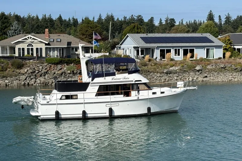 The Image of 1993 Ocean Alexander 423 Classicco yacht cruising near waterfront homes. - 0