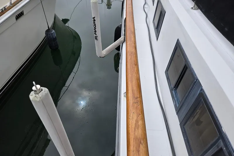 Slide: The Image of 1993 Ocean Alexander 423 Classicco yacht docked, showing deck and water reflection. - 18