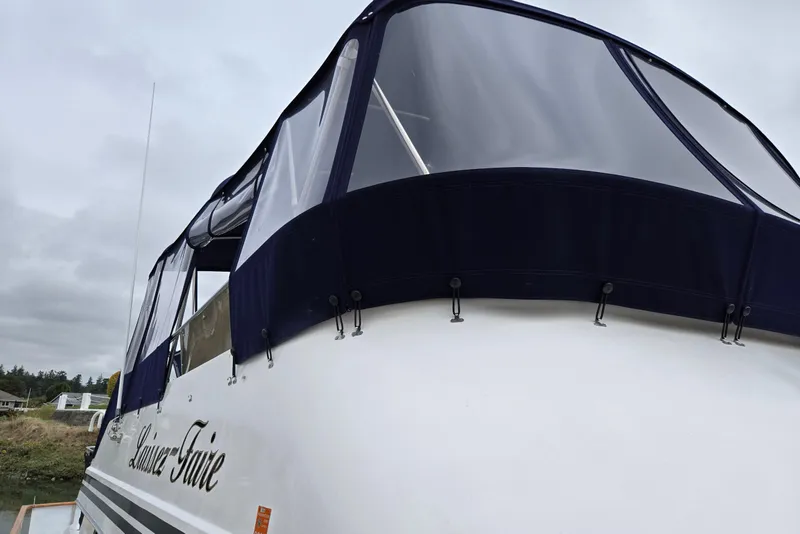 Slide: The Image of 1993 Ocean Alexander 423 Classicco yacht with blue canopy, docked under cloudy skies. - 4
