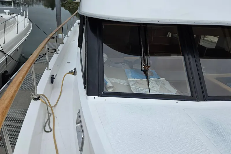 Slide: The Image of 1993 Ocean Alexander 423 Classicco yacht docked, showing deck and cabin windows. - 7