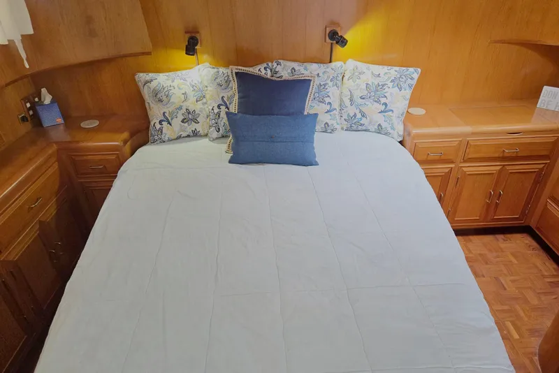 Slide: The Image of Cozy bedroom in 1993 Ocean Alexander 423 Classicco yacht with floral pillows and wooden cabinetry. - 78