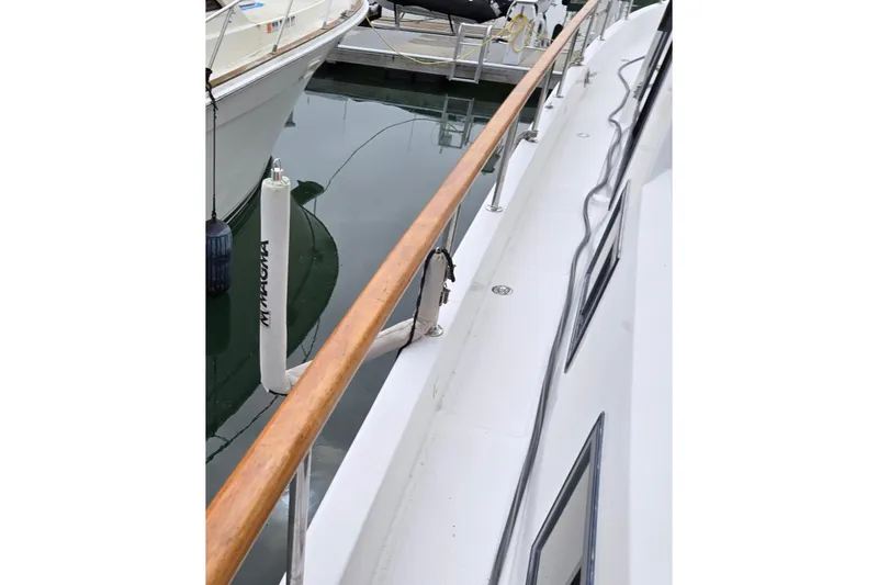 Slide: The Image of 1993 Ocean Alexander 423 Classicco yacht deck with wooden railing and docked boats. - 8