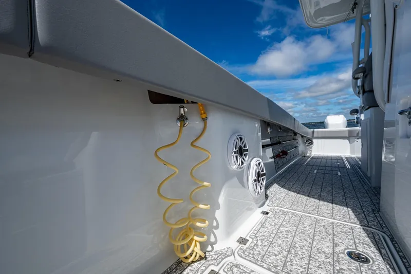 Slide: The Image of 2022 Freeman 34VH boat deck with speakers and coiled hose under blue sky. - 25