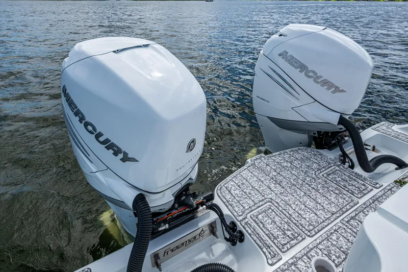 Slide: The Image of Twin Mercury outboard engines on a 2022 Freeman 34VH boat, cruising on water. - 26