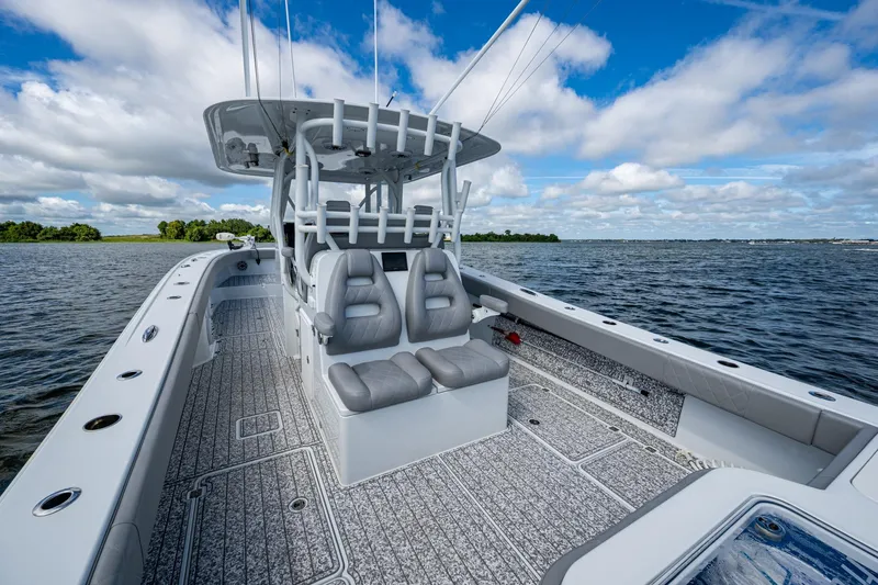 Slide: The Image of 2022 Freeman 34VH boat interior with seating, on a calm lake under a blue sky. - 49