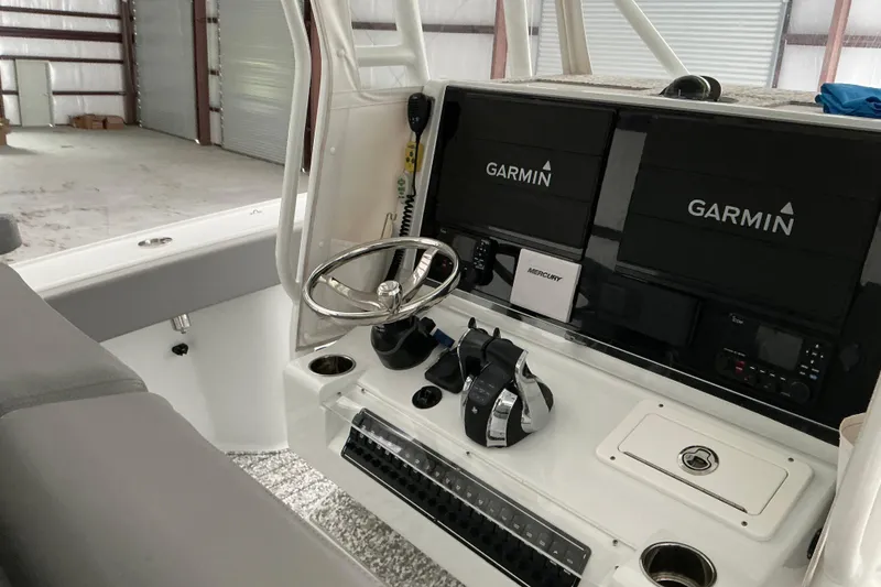 Slide: The Image of 2022 Freeman 34VH boat cockpit with Garmin navigation systems and Mercury controls. - 62