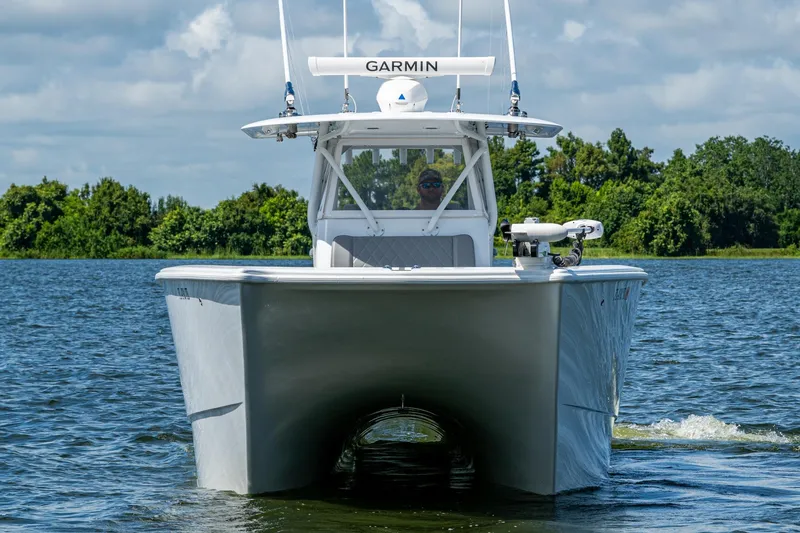 Slide: The Image of 2022 Freeman 34VH boat cruising on a lake with lush green trees in the background. - 8