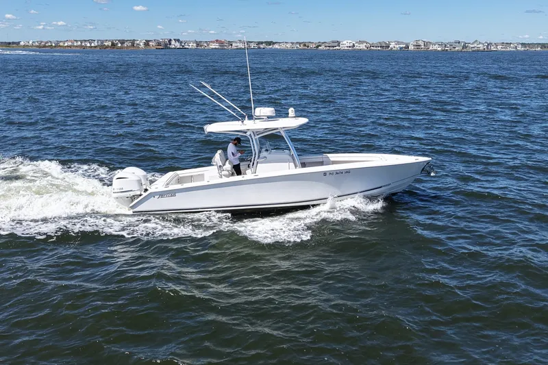 Slide: The Image of 2014 Jupiter 30 FS boat cruising on open water near coastal homes. - 11
