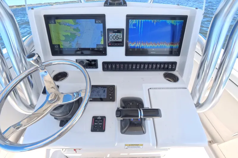 Slide: The Image of Control panel of a 2014 Jupiter 30 FS boat with navigation screens and steering wheel. - 22