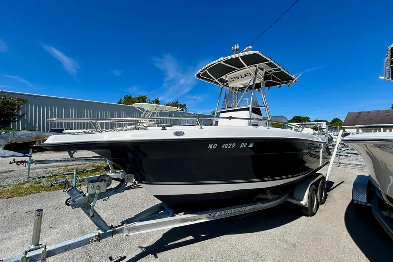 The Image of 2006 Century 2200 Center Console boat on trailer under clear blue sky. - 1