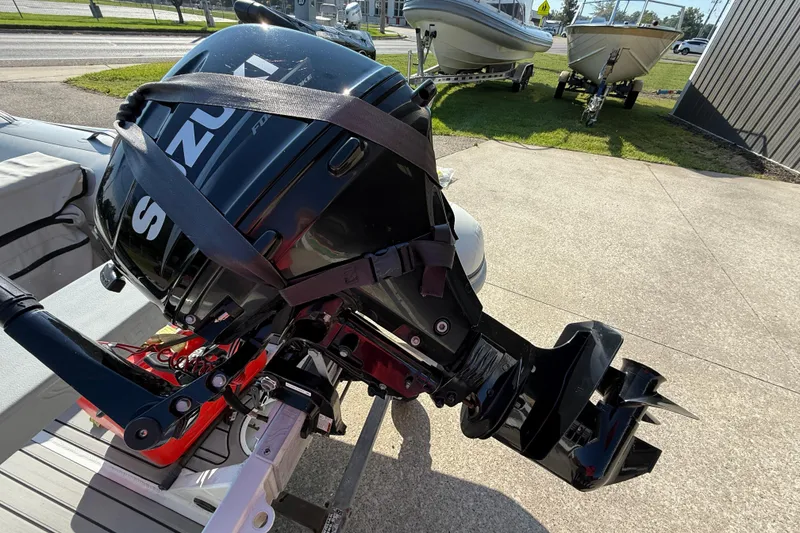 Slide: The Image of 2020 Highfield Classic 310 with outboard motor, parked on concrete, boats in background. - 8