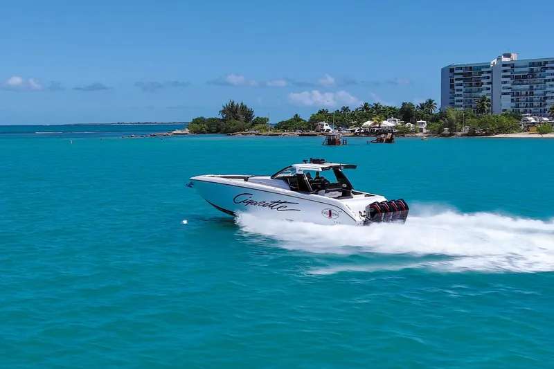 Slide: The Image of 2025 Cigarette 42 Auroris speedboat cruising on turquoise waters near a coastal city. - 10