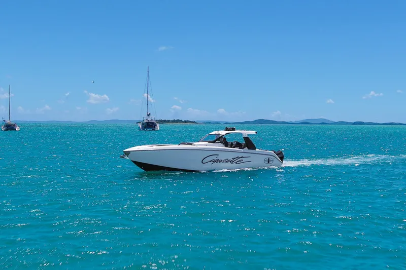 Slide: The Image of 2025 Cigarette 42 Auroris speedboat cruising on turquoise ocean with sailboats in the background. - 11