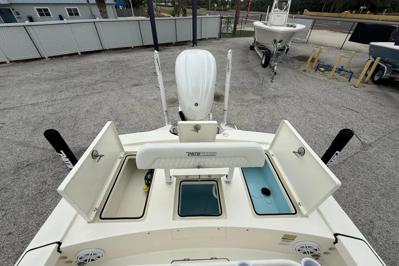 Slide: The Image of 2026 Pathfinder 2300 HPS boat with open storage compartments and motor, displayed outdoors. - 23