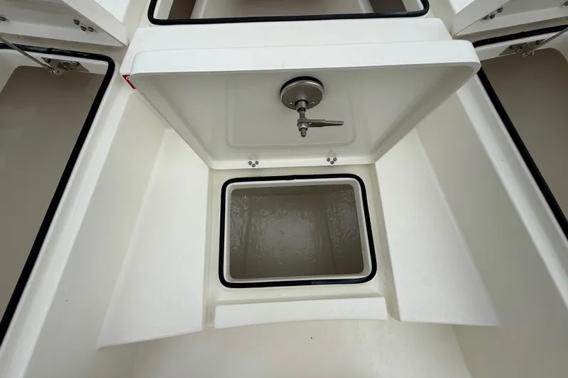 Slide: The Image of 2026 Pathfinder 2300 HPS boat storage compartment with open lid and faucet. - 38