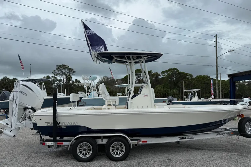 Slide: The Image of 2026 Pathfinder 2300 HPS boat on trailer, displayed outdoors under cloudy sky. - 8
