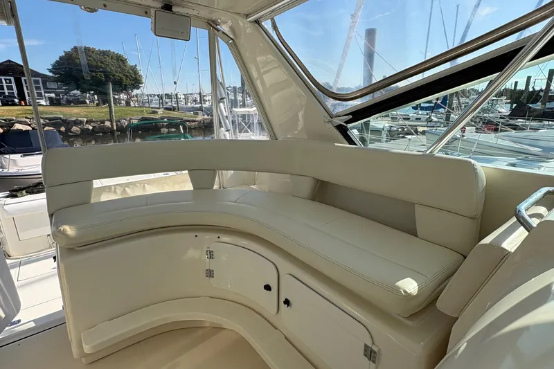 Slide: The Image of 1996 Tiara 4300 Open yacht interior with cream seating and marina view. - 11