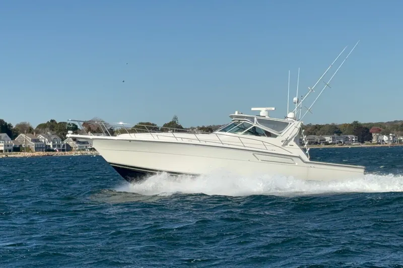 Slide: The Image of 1996 Tiara Yachts 4300 Open cruising on the water near coastal homes. - 7