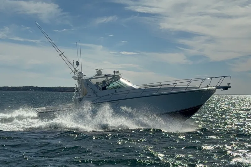 Slide: The Image of Tiara Yachts 4300 Open 1996 cruising on open water under a partly cloudy sky. - 6