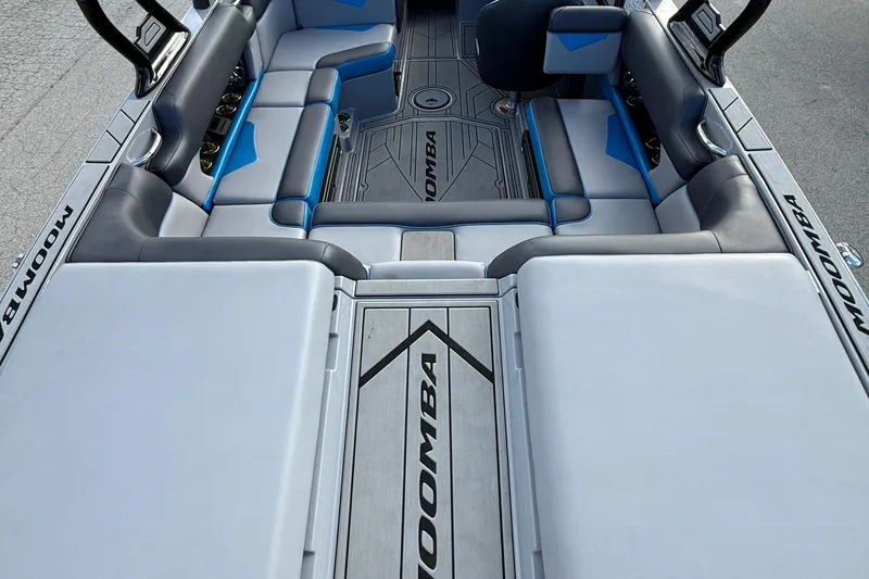 Slide: The Image of 2022 Moomba Kaiyen boat interior with gray and blue seating, showcasing spacious design. - 12