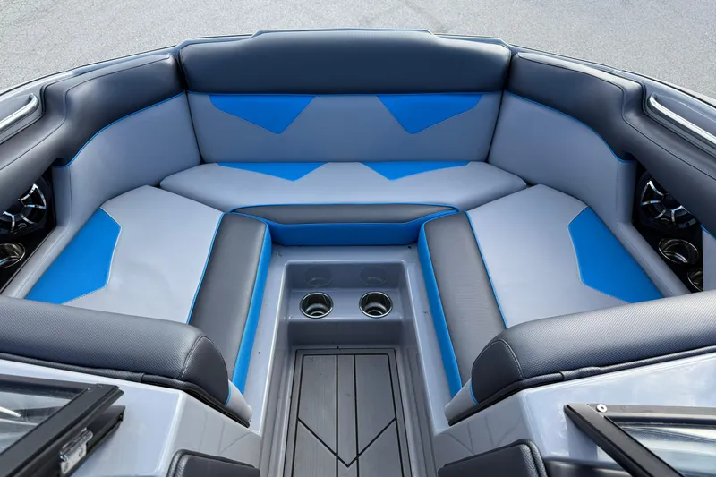 Slide: The Image of 2022 Moomba Kaiyen boat interior with blue and gray seating, cup holders, and speakers. - 14