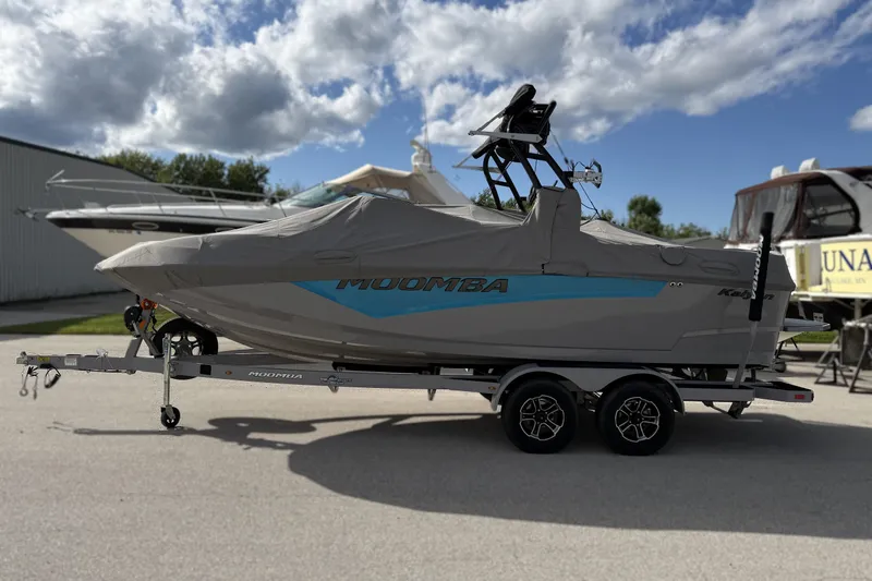 Slide: The Image of 2022 Moomba Kaiyen boat on trailer, covered, under a partly cloudy sky. - 30