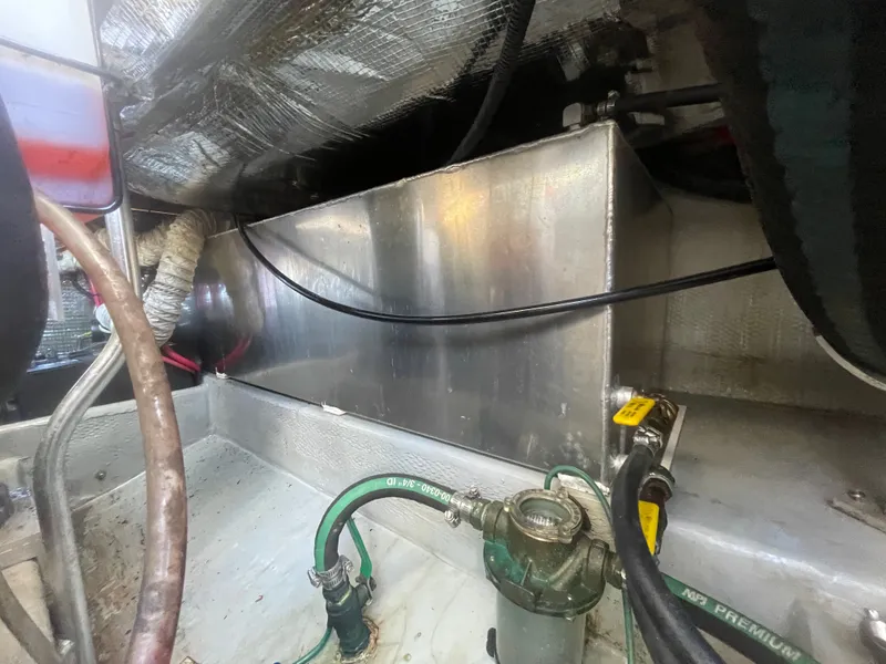 Slide: The Image of Engine compartment of 2005 Mainship Pilot 30-II, showing fuel lines and metal components. - 18