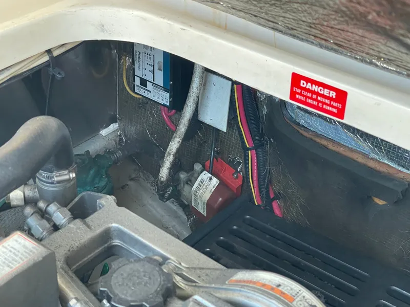 Slide: The Image of Engine compartment of 2005 Mainship Pilot 30-II with visible wiring and warning label. - 23