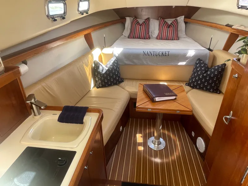 Slide: The Image of 2005 Mainship Pilot 30-II cabin interior with cozy seating, kitchenette, and bed. - 25
