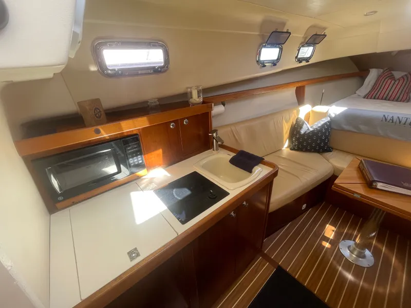Slide: The Image of 2005 Mainship Pilot 30-II cabin interior with kitchenette, seating, and bed. - 28