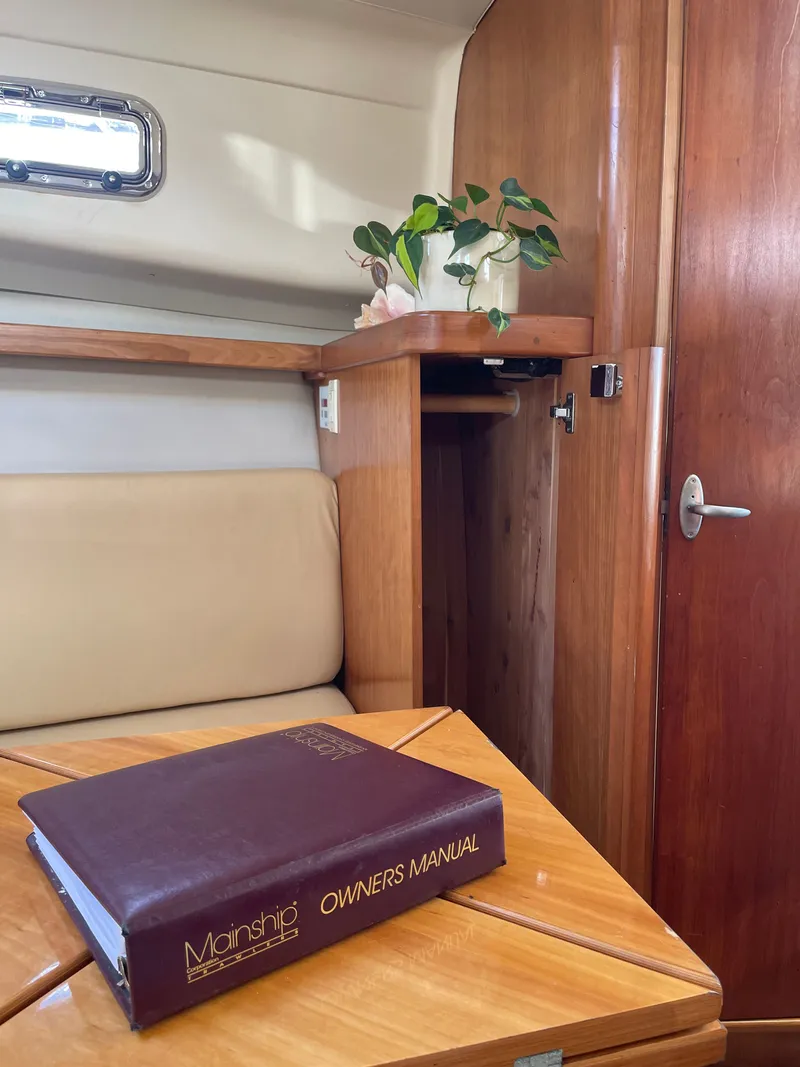 Slide: The Image of Interior of 2005 Mainship Pilot 30-II with owner's manual on table. - 34