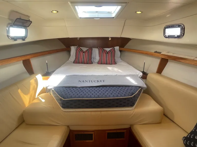 Slide: The Image of 2005 Mainship Pilot 30-II cabin interior with bed, cushions, and portholes. - 38