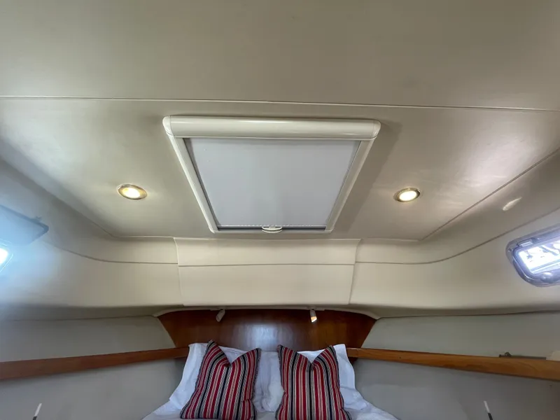 Slide: The Image of 2005 Mainship Pilot 30-II cabin interior with skylight and striped pillows. - 43