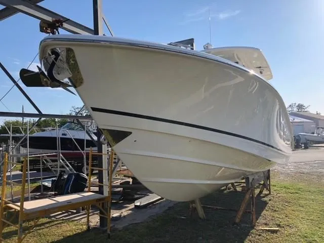 Slide: The Image of 2017 Boston Whaler 330 Outrage boat on dry dock, side view. - 4