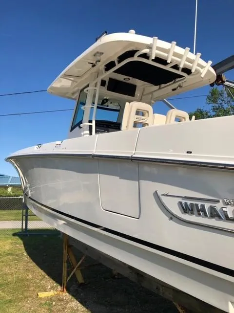 Slide: The Image of 2017 Boston Whaler 330 Outrage boat with sleek design, docked outdoors. - 6