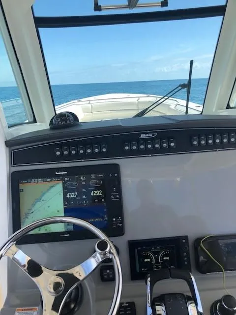 Slide: The Image of 2017 Boston Whaler 330 Outrage helm with navigation system, steering wheel, and ocean view. - 7