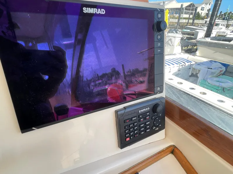 Slide: The Image of Simrad navigation system on a 2015 Fortier 30 boat, docked at a marina. - 12