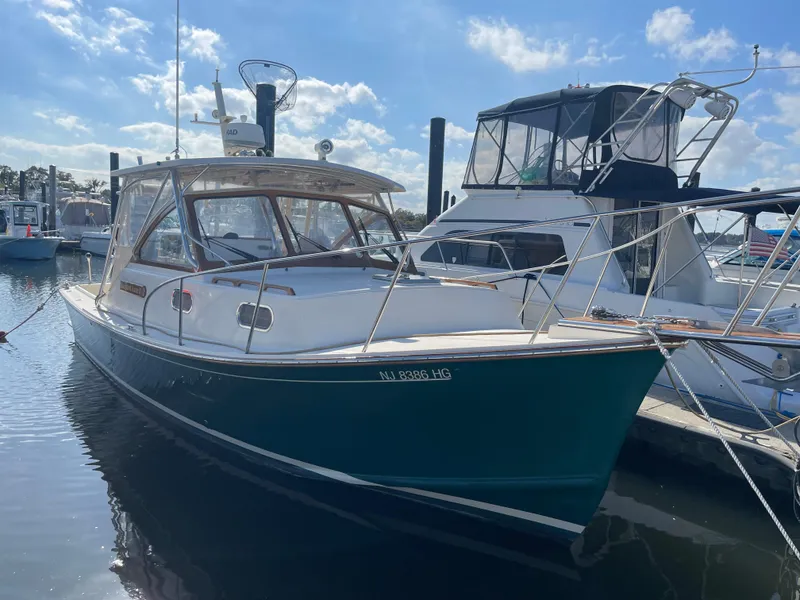Slide: The Image of 2015 Fortier 30 boat docked at marina under blue sky. - 2