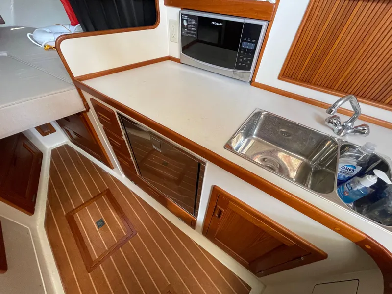 Slide: The Image of Fortier 30 boat interior kitchen with sink, microwave, and wooden cabinetry, 2015 model. - 20
