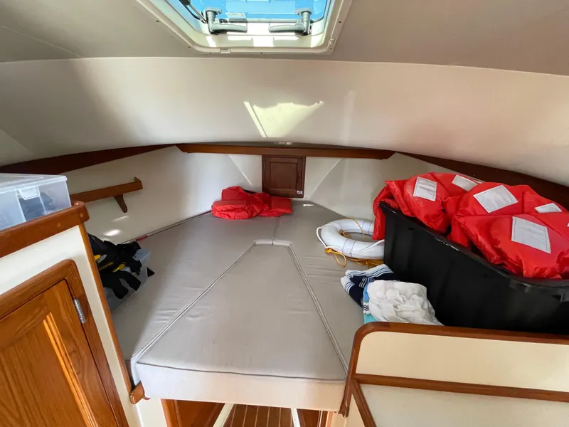 Slide: The Image of 2015 Fortier 30 cabin interior with storage, life jackets, and skylight. - 21