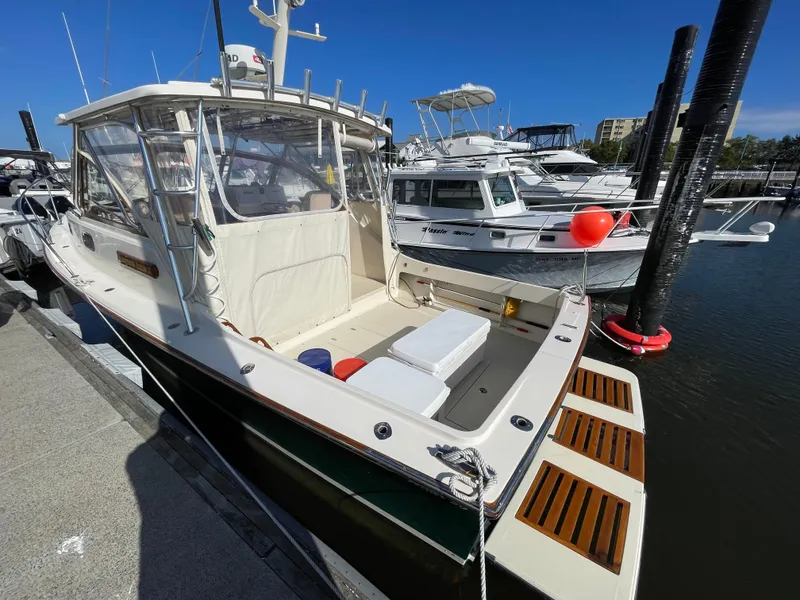 Slide: The Image of 2015 Fortier 30 boat docked at marina, clear day, other boats in background. - 3