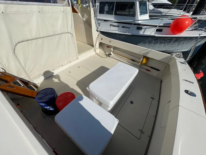 Slide: The Image of Fortier 30 boat deck with storage, coolers, and docked vessels in background, 2015 model. - 40