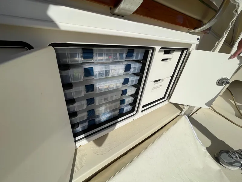 Slide: The Image of Storage compartment with organized containers on a 2015 Fortier 30 boat. - 43