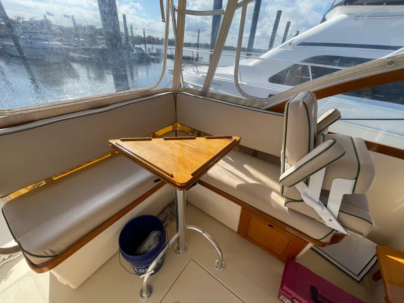 Slide: The Image of Interior of 2015 Fortier 30 boat with seating, table, and marina view. - 6