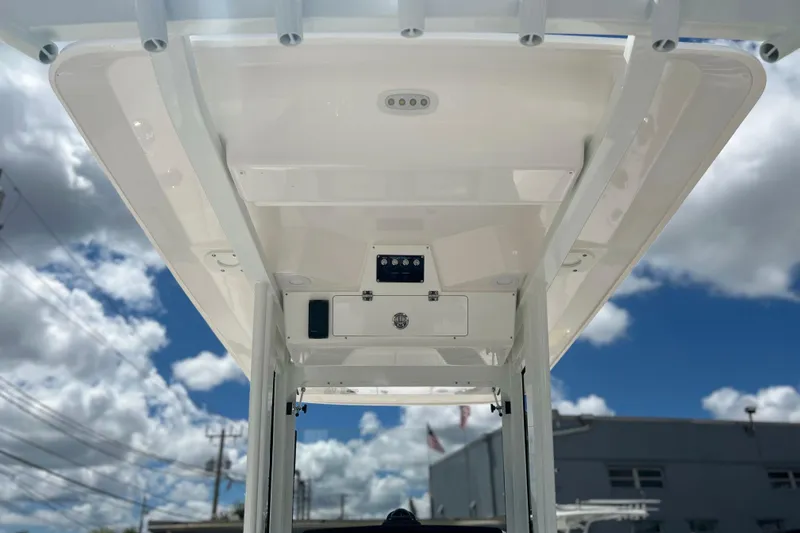 Slide: The Image of 2026 Sea Fox 268 Commander boat canopy under a bright blue sky with clouds. - 33